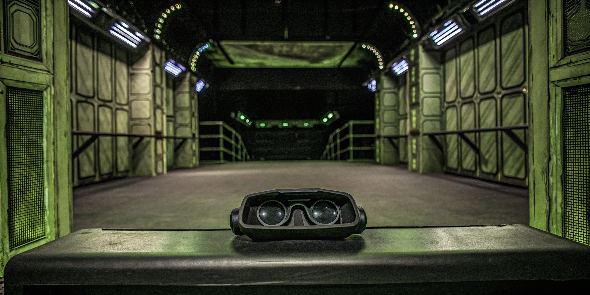 Wireless VR gear on a bench in a futuristic zero latency arena with green lighting
